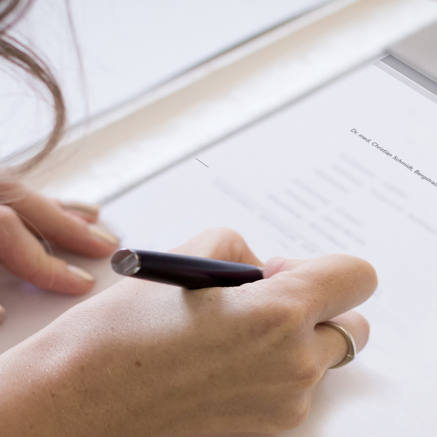 Hand mit Stift - Formular wird ausgefüllt